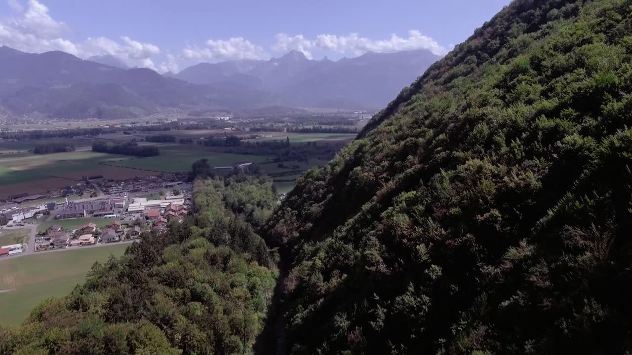vuelo aéreo sobre un pueblo y un arroyo en el bosque