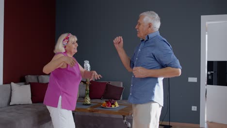 Feliz-Pareja-De-Ancianos-Bailando-Divirtiéndose-Celebrando-El-Aniversario-De-Jubilación-En-El-Salón-De-Casa