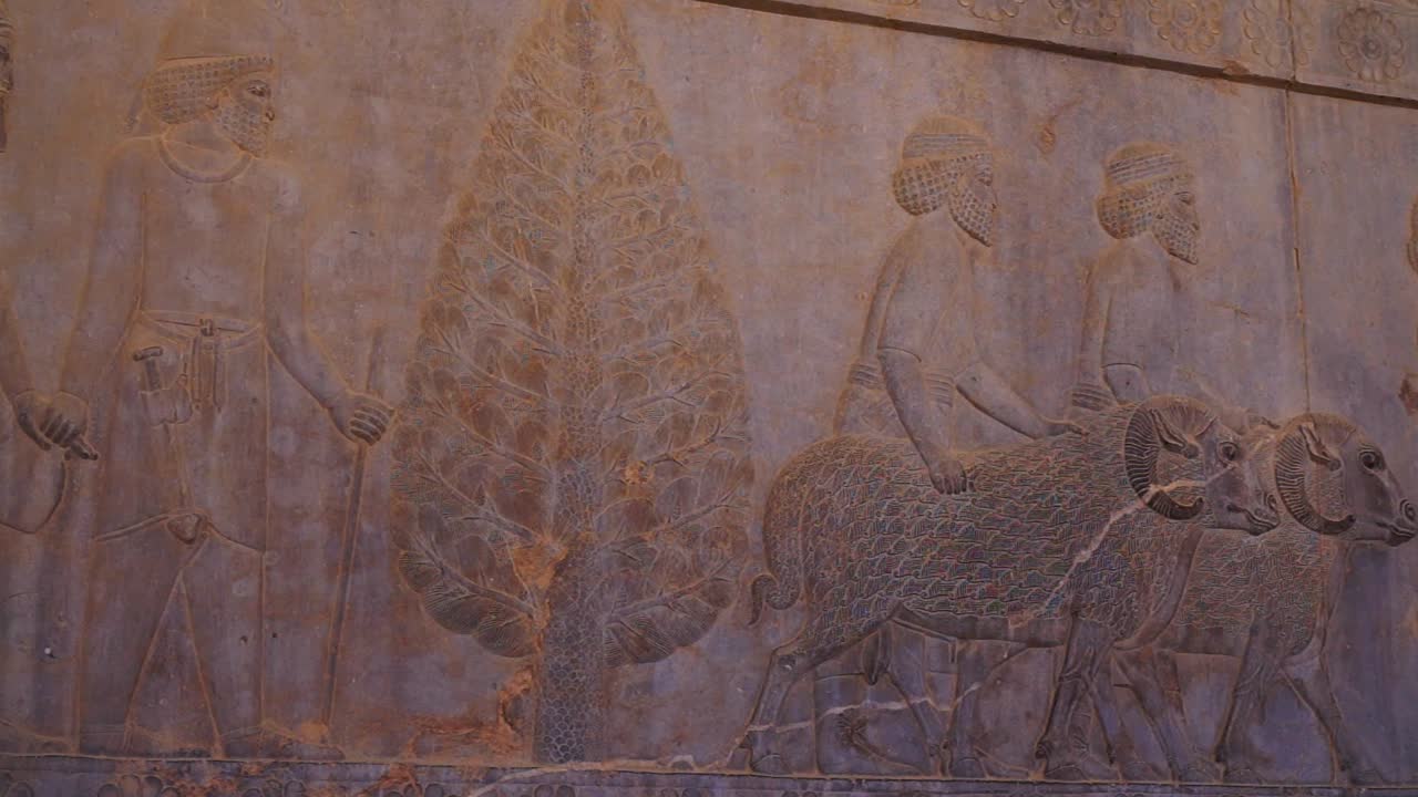 Panning right | People Giving Tributes Relief | Ancient ruins of Persepolis near Shiraz, Southern Iran. This walls's relief shows many things in the past of Persian empire | Silk Road Iran