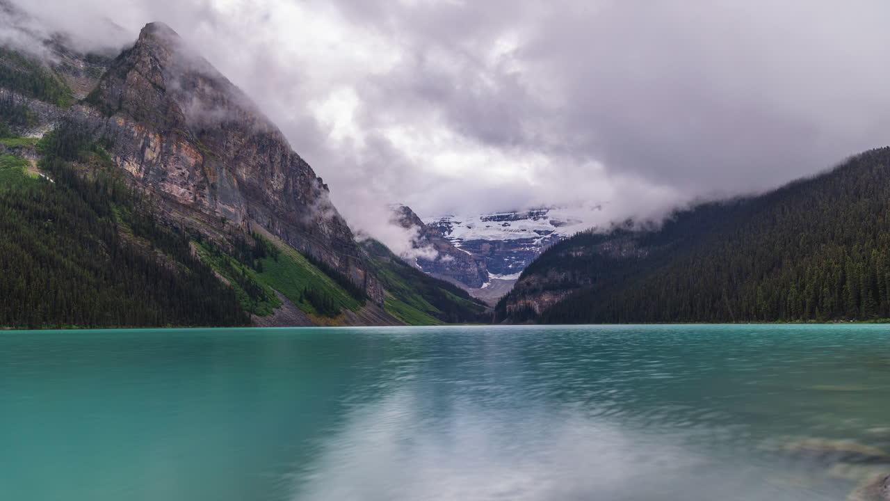 Timelapse of moody skies over Lake Louise, with shifting clouds and calm turquoise waters in Banff National Park