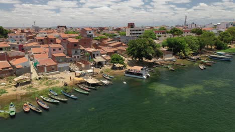 Vista-Aérea-Del-Pueblo-De-Pescadores,-Barcos-De-Pesca,-Casas-A-Orillas-Del-Río-São-Francisco,-Frontera-De-Los-Estados-De-Bahia-Y-Pernambuco