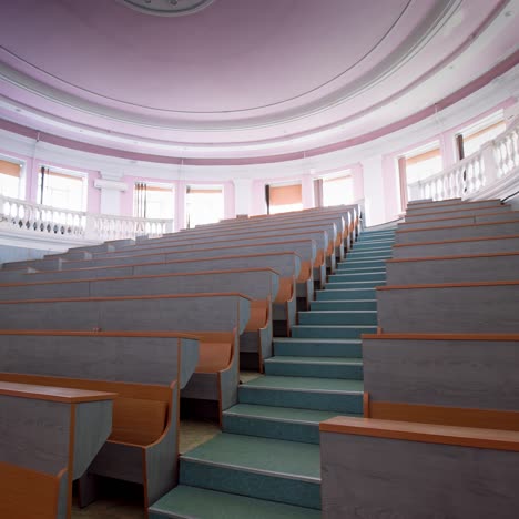 modern auditorium with stairs. many rows of wooden desks rising up in the conference hall. spacious classroom for lectures in the university