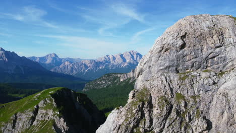 Paisaje-Aéreo-De-Pradera-Cubierta-De-Hierba-Entre-Los-Picos-De-Las-Montañas-Dolomitas-En-El-Horizonte-Azul-En-Italia-En-Un-Día-De-Verano