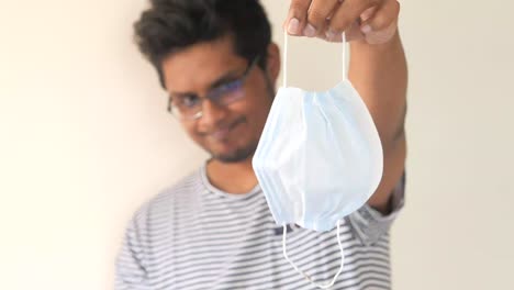 man holding a disposable face mask