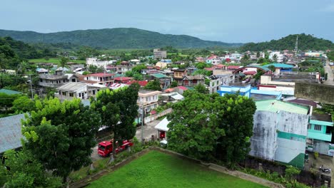 approaching aerial view of holy cross atop local cathedral revealing simple town village in bato, catanduanes