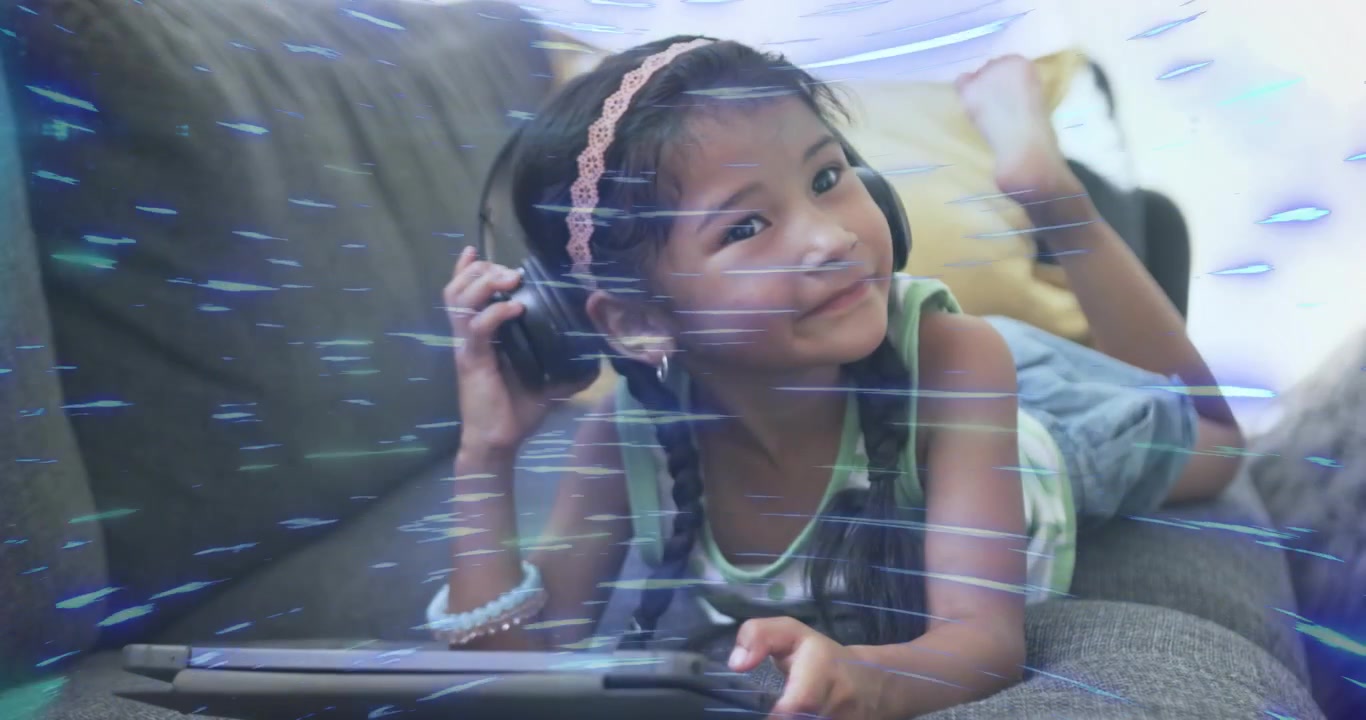 Child swiping tablet on couch wearing headphones hearing education audio showing glitch and smiling