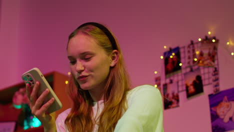 young woman smiling while looking at her phone