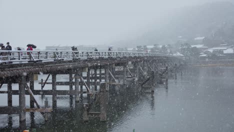 Arashiyama-in-Kyoto,-Snow-Flakes-falling-over-Togetsukyo-Bridge