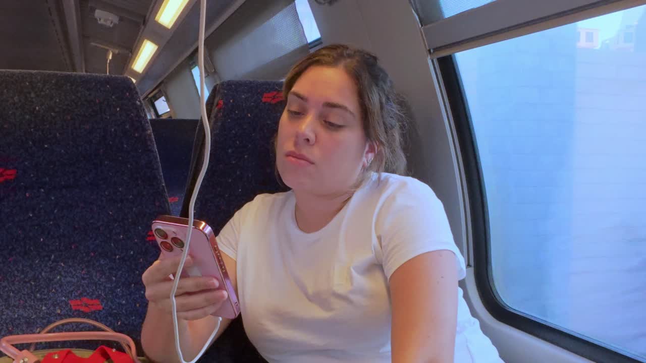 Woman Using Her Phone on a Train During an Evening Commute