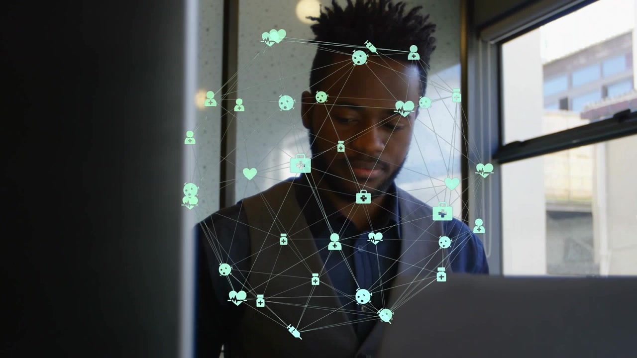 Animation of globe of digital icons against african american businessman using laptop at office