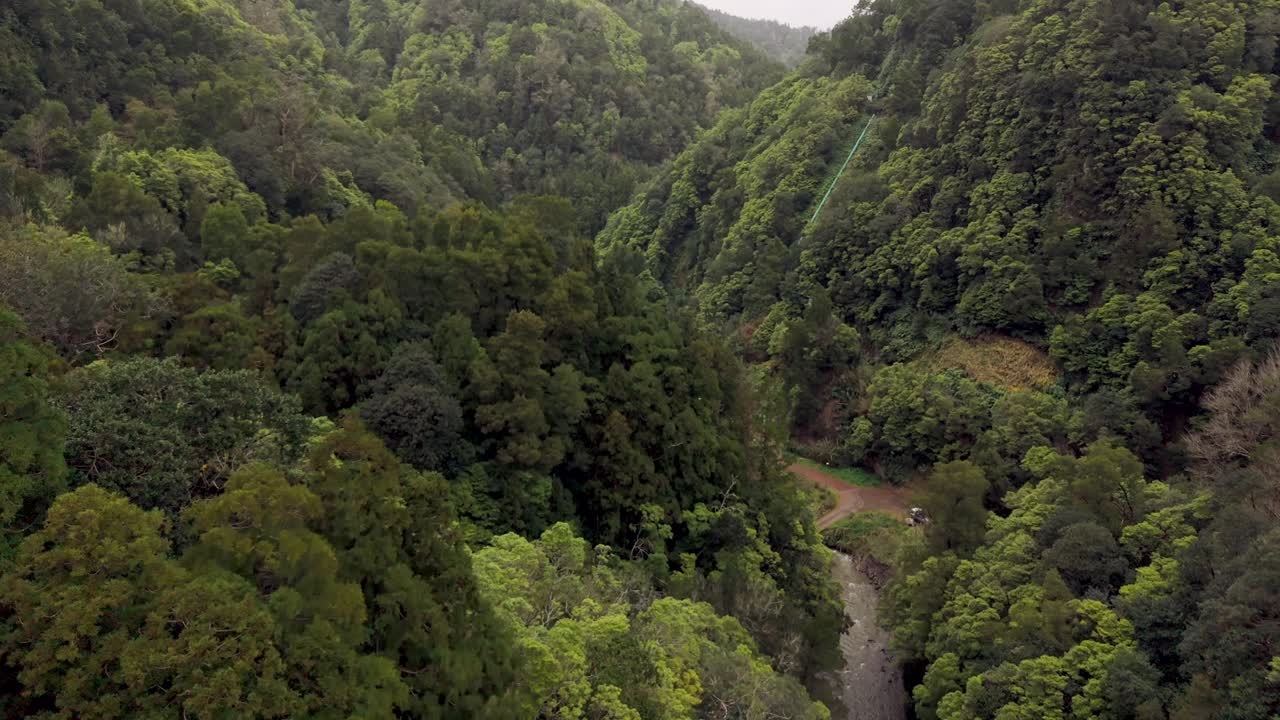 Vista aérea do vale de floresta densa e rio em São Miguel, Açores