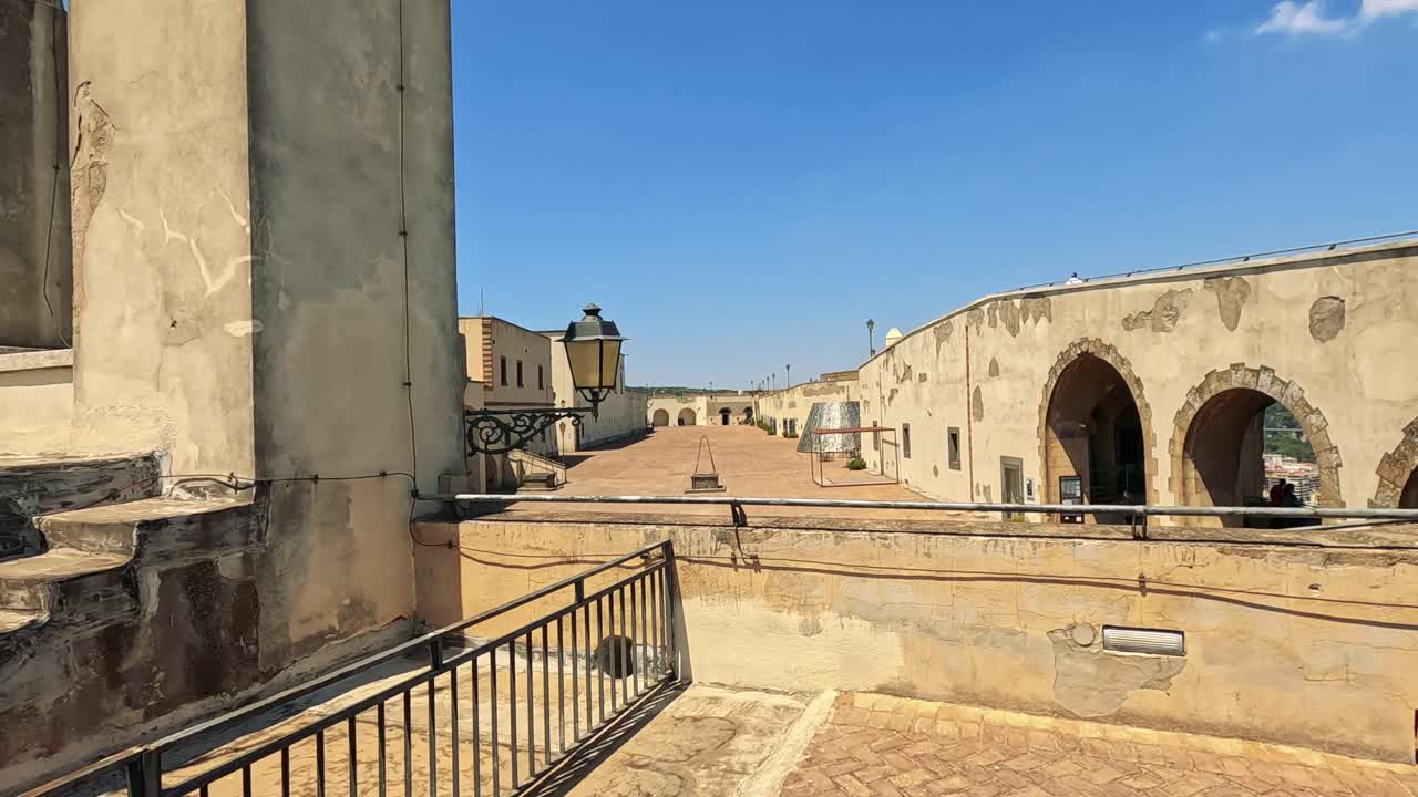 los visitantes caminan a través de un patio del castillo soleado