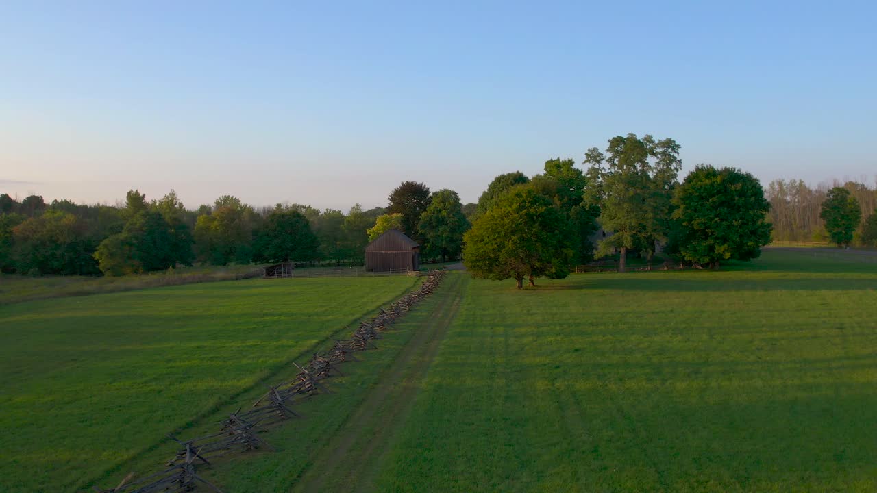 el dron se acerca al lado de una valla cerca de la granja de la familia joseph smith, la casa de madera, el templo, el centro de visitantes y la arboleda sagrada en palmyra lugares de origen de nueva york el libro de mormón