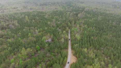 imágenes aéreas estáticas de dos vehículos conduciendo lentamente por un camino de tierra en el valle de sequatchie en el este de tennessee