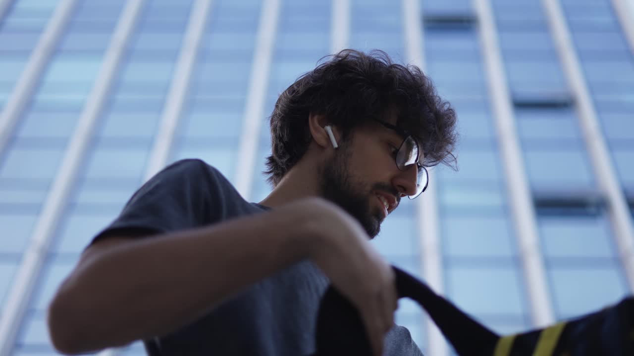 배 ⁇ 을 들고 있는 택배 운송사 가 가방 안 을 보고, 낮은 각도 로 보는 것