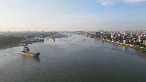 Timelapse-Aéreo-Sobre-El-Puerto-Fluvial-Con-Vistas-A-La-Ciudad-Junto-Al-Río,-Concepto-De-Ruta-Del-Canal-Comercial---Toma-De-Vuelo-De-Drones