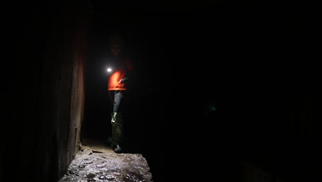 worker inspecting underground tunnel