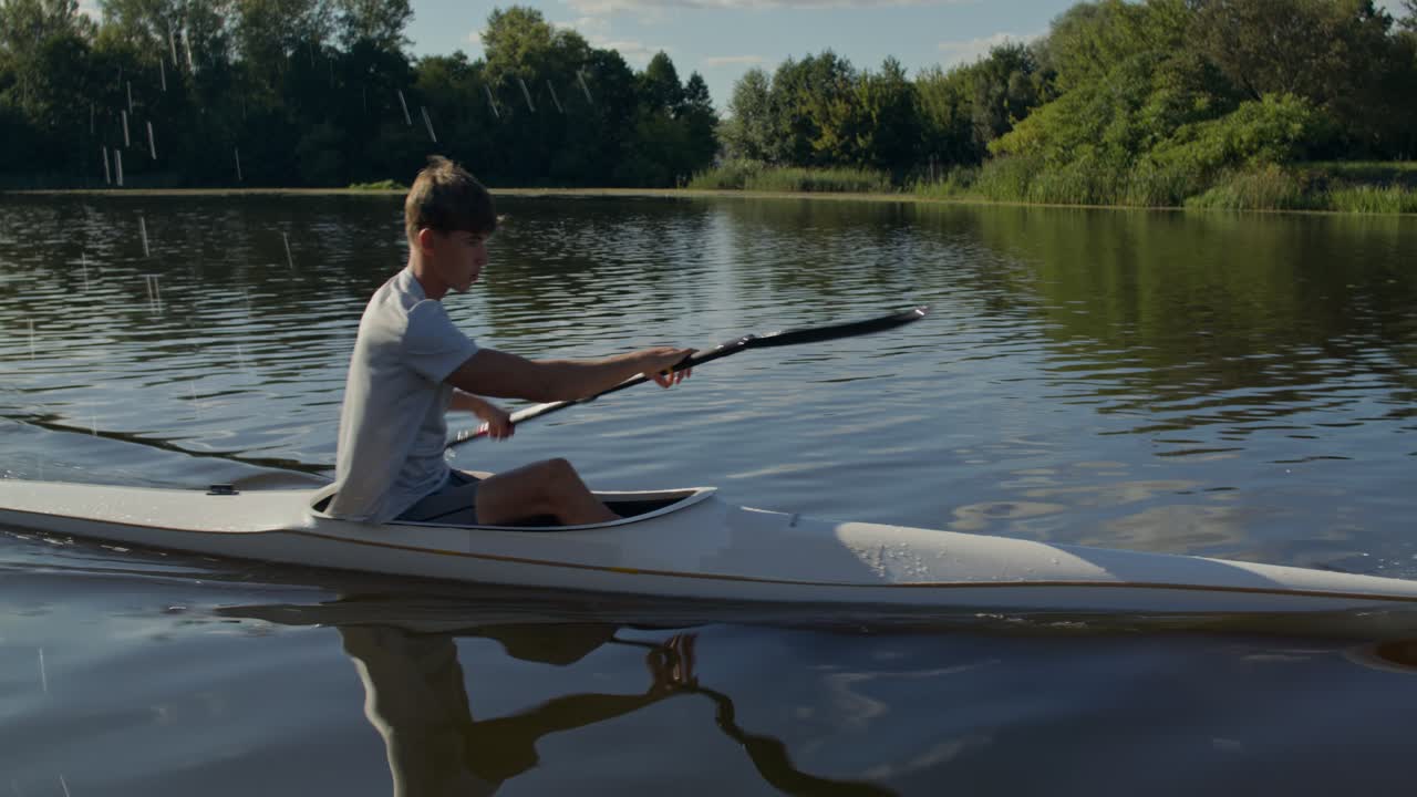 Un giovane uomo che va in kayak su un lago calmo