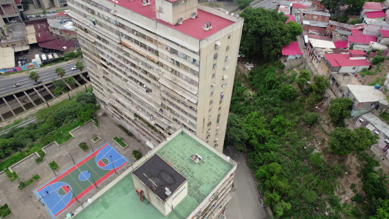 Drone shot of an urban basketball court next to a large residential building