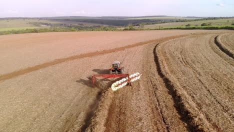 tractor raking sugar cane straw in the field