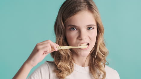 teenage caucasian girl in pijamas brushing her teeth.