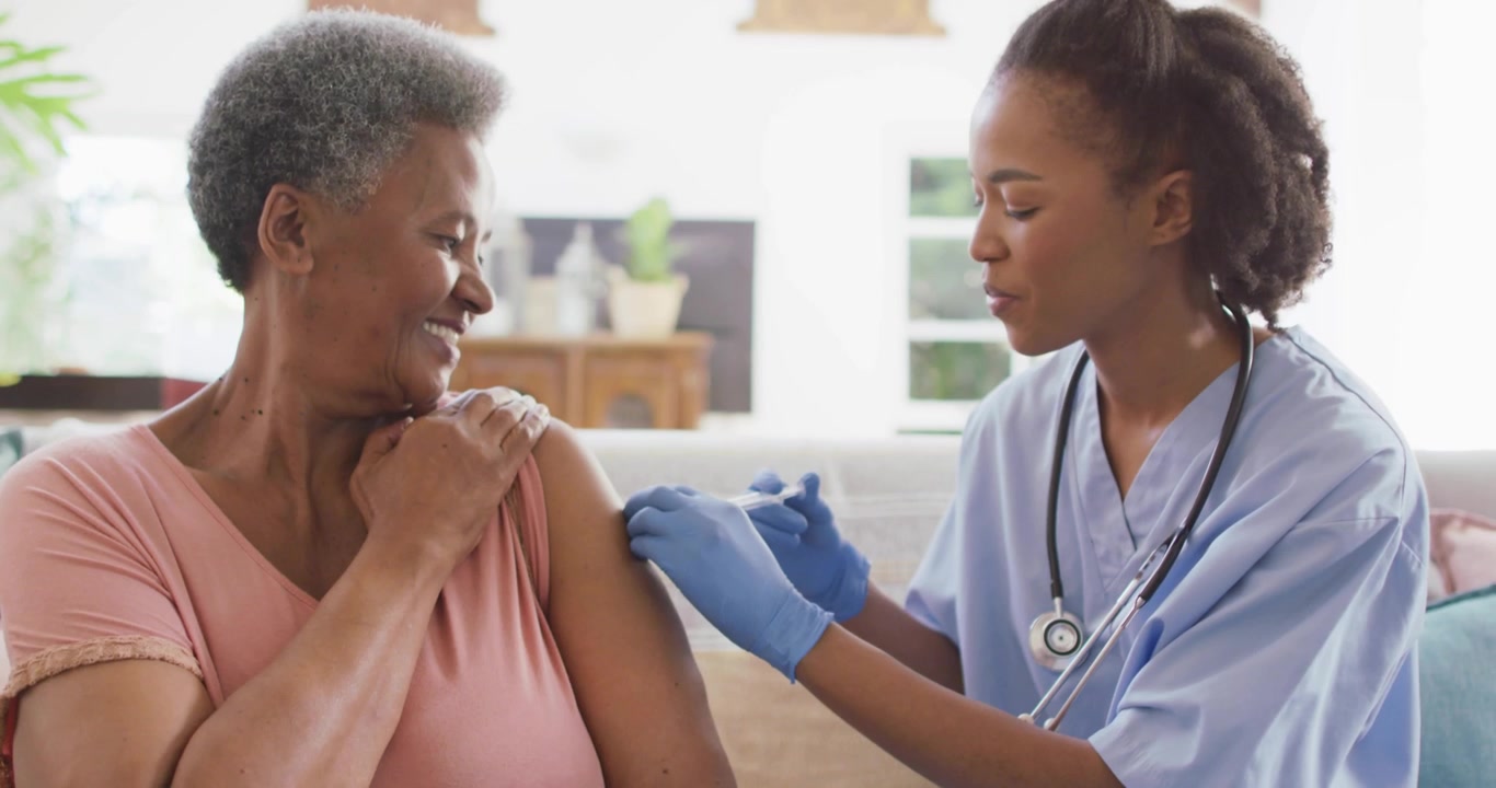 Nurse Administering Vaccine to Senior Woman at Home