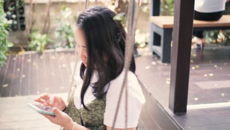 woman using smartphone on a swing