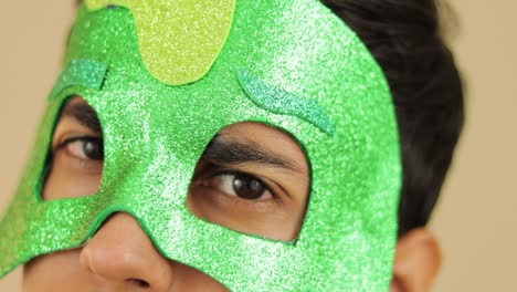 young man using glittered cartoon green mask and smiling at camera