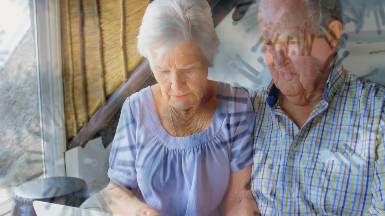 코로나19 세포는 노인 부부에게 노트북을 사용해 공격한다.