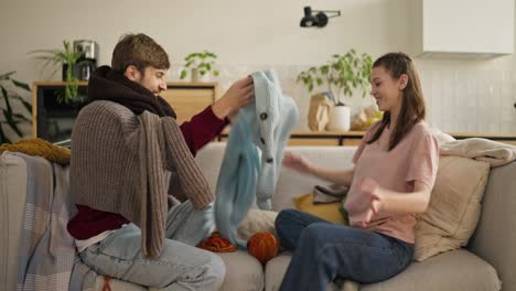 couple playing with knitted sweater
