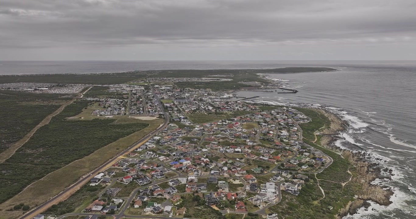 Gansbaai, Etelä-Afrikka, ilmakuva v6 korkea pilvinen ylilento rannikon, asuinalueiden ja rannikkokaupunkimaiseman yllä – Kuvattu Mavic 3 Pro Cine -kameralla – 7. tammikuuta 2024