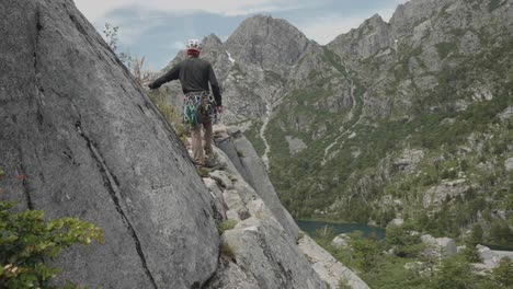 climber walking on a ledge of a pristine granite wall