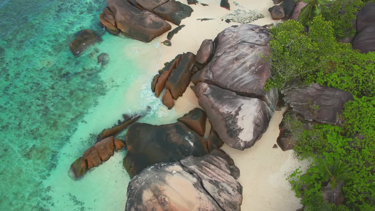 Batu-batu besar di Pantai Baie Lazare, sebuah pantai yang terletak di Pulau Mahe di pesisir barat daya, air pirus, pantai berpasir putih