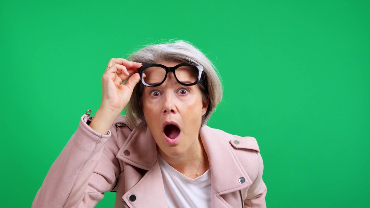 Surprised senior woman seeing something unbelievable on green screen