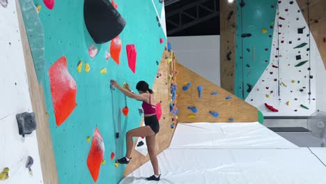 woman bouldering in a climbing gym