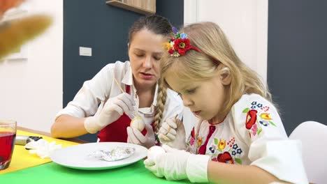 madre e hija decorando huevos de pascua