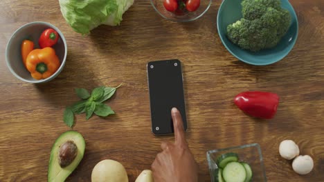 video of healthy fruit and vegetables and smartphone on wooden background