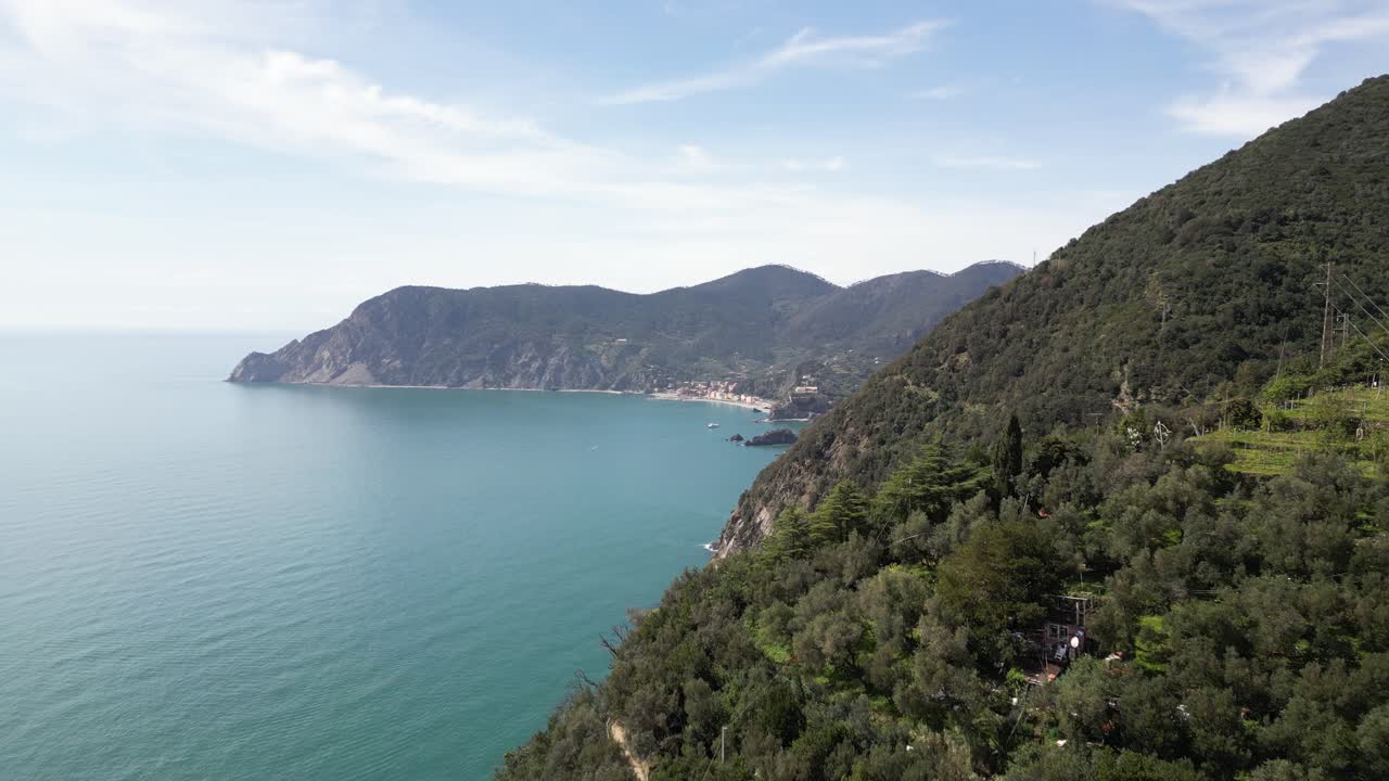 Monterosso Cinque Terre Italia, volo aereo inverso sopra le scogliere che mostra il villaggio da lontano.