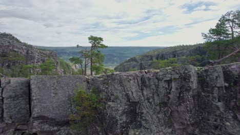 a drone shoots past a cliff revealing the natural beauty of the jutulhogget canyon