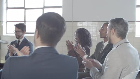 subordinados alegres aplaudiendo a una oradora exitosa