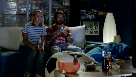 expressive couple playing videogame at home