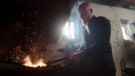 blacksmith heating up iron in his forge