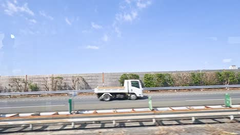 Vehicles move along a Tokyo highway under clear skies, showcasing urban transport dynamics and infrastructure