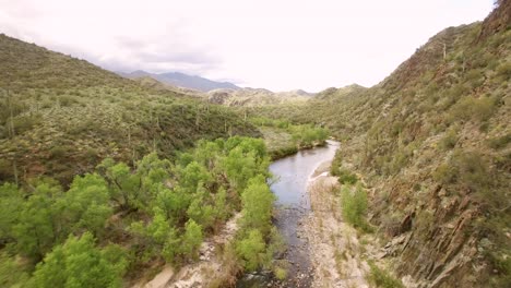 aerial pull back to reveal the aqua fria river, flowing through a desert canyon, arizona
