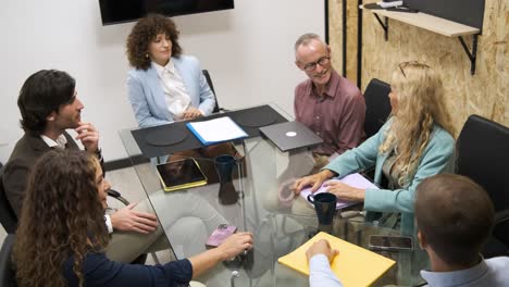 Happy businesswoman discussing strategy with colleagues during conference meeting