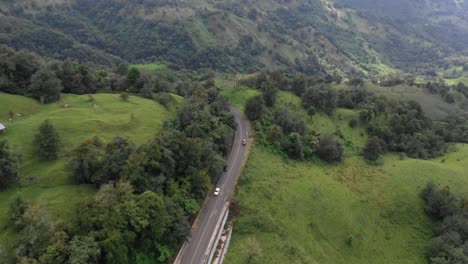 aerial view of a winding mountain road through lush green hills
