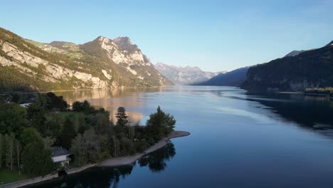 Eine-Wunderschöne-Luftaufnahme-über-Dem-Walensee-Mit-Beeindruckenden-Sonnenverwöhnten-Bergen-Und-Glitzerndem-Wasser-In-Der-Schweiz