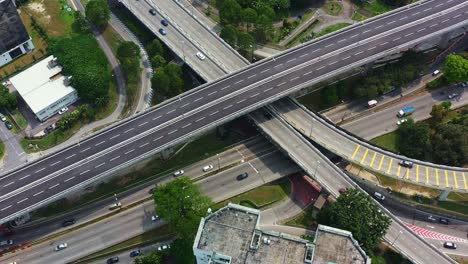 aerial flyover busy traffics on complex overpass and underpass connecting lebuhraya persekutuan and e37 salak highway at seputeh, kuala lumpur, tilt up reveals midvalley megamall shopping center