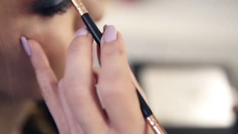 Side-view-of-young-model-during-the-make-up-process.-Artist-makes-contours-and-apply-brown-shadow-on-an-eyebrow-with-brush