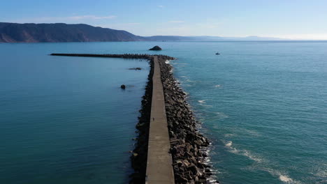 aerial flyover, jetty into the pacific ocean in sunny northern california